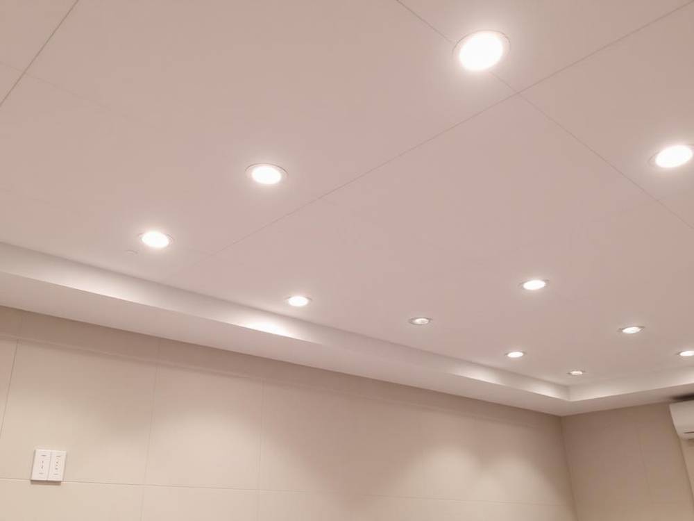Finished basement with new LED pot light installation replacing old fluorescent lighting